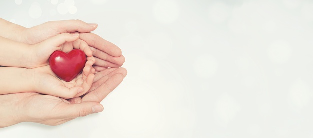 Parent Who Received Family Planning Services Holding Child's Hand Holding a Heart