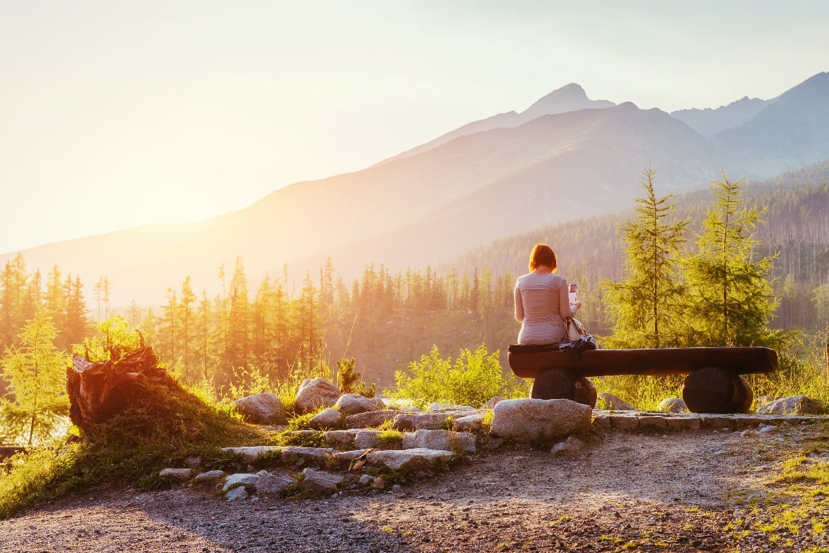 Woman with Essure sitting on bench at sunset